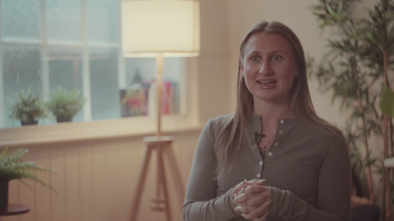 A woman sharing her story in a warmly lit interview